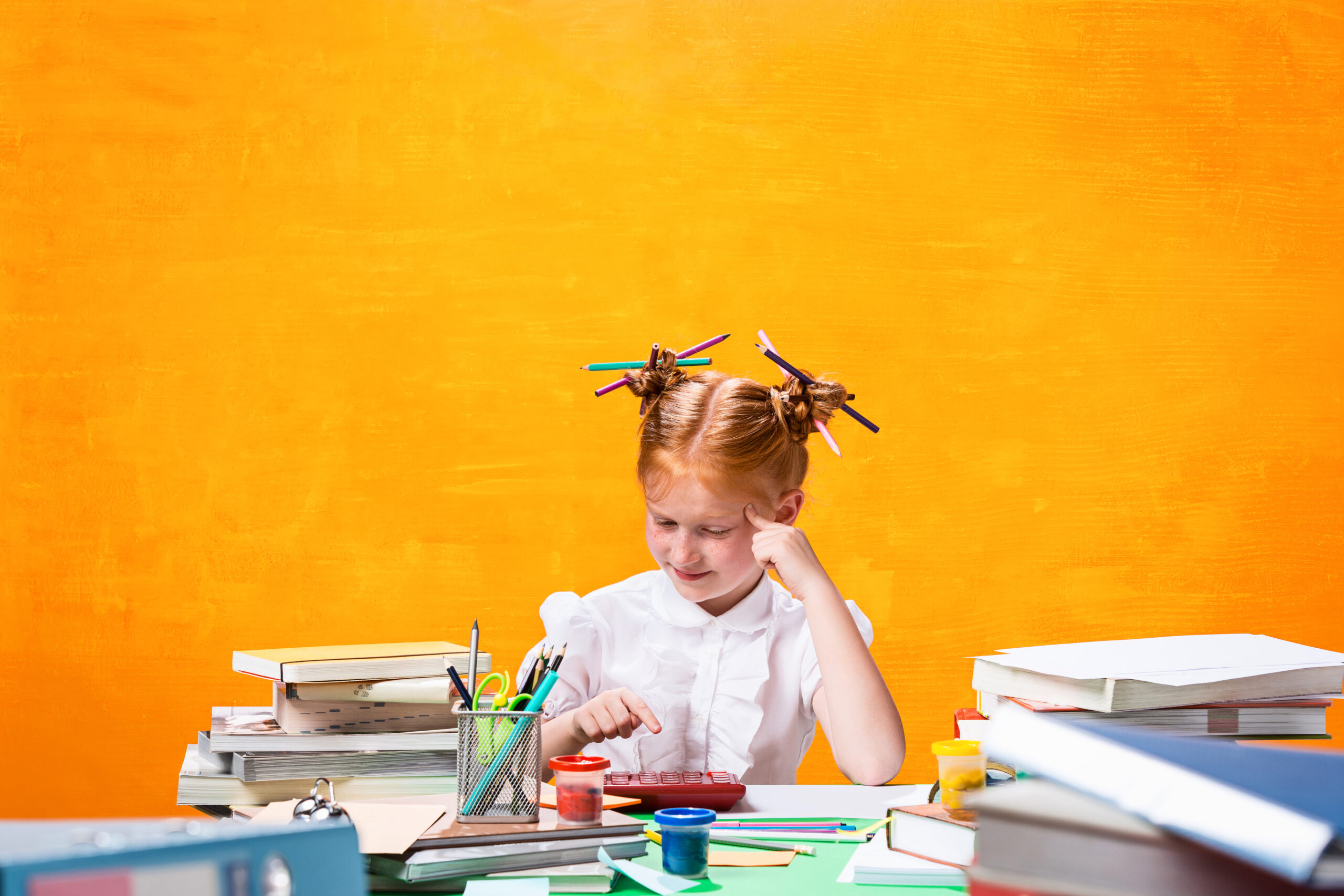 The Redhead teen girl with lot of books at home. Studio shot