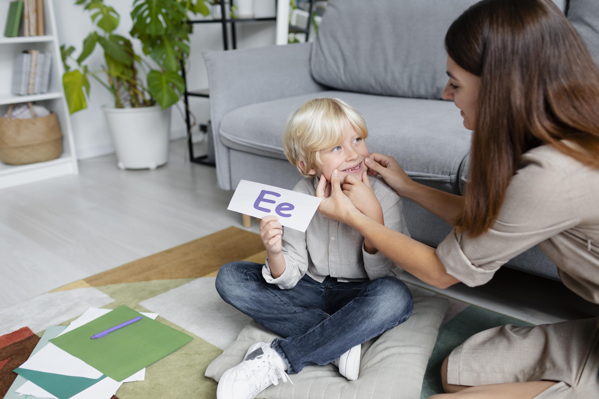 young-woman-doing-speech-therapy-with-little-blonde-boy